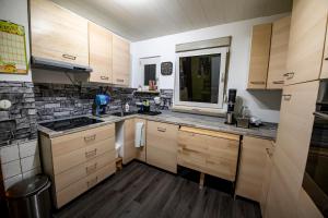 cocina con armarios de madera y encimera en Schöne Ferienwohnung in ruhiger Lage en Altena