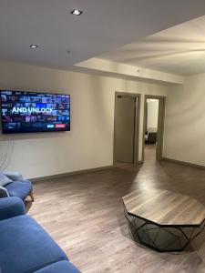 - un salon avec un canapé et une télévision murale dans l'établissement Comfortable 2+1 apartment - near of mall of Istanbul, à Istanbul