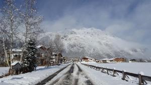 a snow covered road with a mountain in the background at Mountain Motel ohne Frühstück in Leutasch