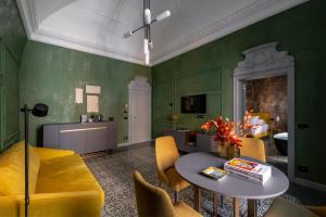 a living room with green walls and a table and chairs at VIS Urban Suites&Spa in Bari