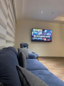 een woonkamer met blauwe banken en een flatscreen-tv bij Comfortable 2+1 apartment - near of mall of Istanbul in Istanbul