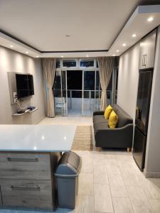 a kitchen and living room with a couch and a tv at 1204 Ten South Beach Apartment in Durban