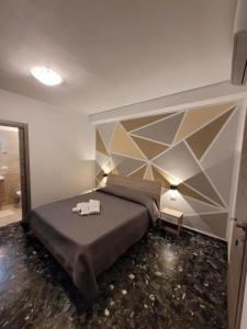 a bedroom with a large bed with a geometric headboard at "Fly to Venice" Airport in Tessera