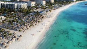 an aerial view of a beach with umbrellas and the ocean at Bocobay Aracari Condo Hotel in Palm-Eagle Beach