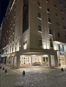 un grand bâtiment situé dans une rue de la ville la nuit dans l'établissement M Concept Hotel, à Buenos Aires