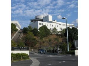 a building on top of a hill with a street at Kansai Airport Spa Hotel Garden Palace - Vacation STAY 72631v in Izumi-Sano