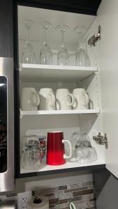 a cupboard filled with cups and plates and glasses at Fully Separate & Private Guest Suite in Edmonton