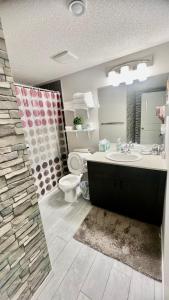 a bathroom with a sink and a toilet and a mirror at Fully Separate & Private Guest Suite in Edmonton