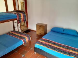 a room with two beds and a wooden cabinet at Quinta Maria in Fusagasuga