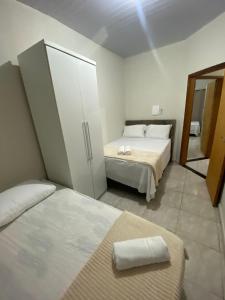 um quarto de hotel com duas camas e um espelho em Casa confortável na terra das cataratas em Foz do Iguaçu