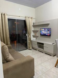 uma sala de estar com um sofá e uma televisão de ecrã plano em Casa confortável na terra das cataratas em Foz do Iguaçu