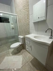 bagno bianco con servizi igienici e lavandino di Casa confortável na terra das cataratas a Foz do Iguaçu