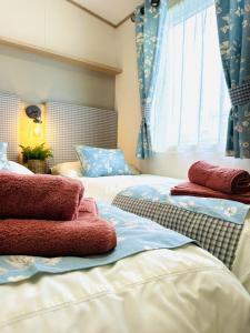 two beds in a room with blue curtains and red towels at Los Jameos in Scarborough