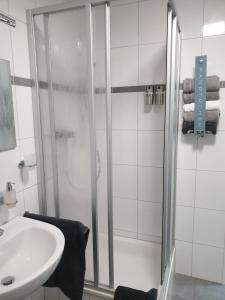 ein Bad mit einer Dusche und einem Waschbecken in der Unterkunft Bataver in Neuss