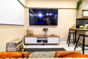 a living room with a large flat screen tv at STUDIO/ESTÚDIO TOP - Praia 200M & Lazer Incrível / Stylish Stúdio - 200M Beach & Great Amenites in Maceió
