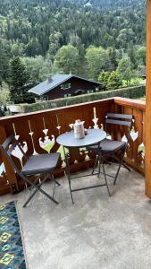 a table and chairs on a balcony with a view at Chalet luxueux in Châtel
