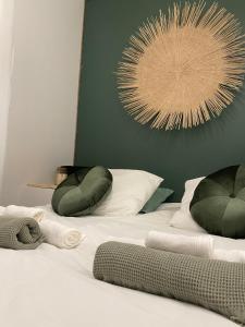 een wit bed met twee kussens erop en een schilderij bij Logement de charme Toulouse in Toulouse