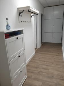 a room with white cabinets and a hallway with wood floors at Bataver in Neuss