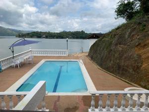 een zwembad op een terras naast het water bij Hermosa Cabaña en Isla privada Prado Tolima in Prado