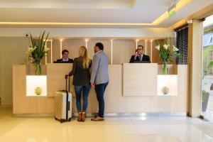 a man and a woman with a suitcase standing in a lobby at M Concept Hotel in Buenos Aires