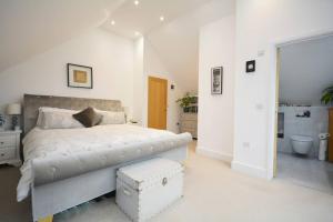 - une chambre blanche avec un lit et une salle de bains dans l'établissement Detached modern home with stunning views, à Buckinghamshire