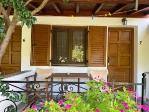 a porch with a table and chairs and a window at Maniatis Garden in Achladies