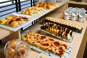 a table with different types of pastries and pies at M Concept Hotel in Buenos Aires