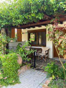 a patio with a table and chairs in a garden at Maniatis Garden in Achladies