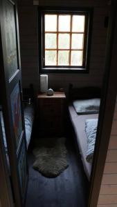 a small room with two beds and a window at Bregnehytte in Leikanger