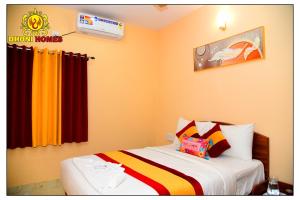 a bedroom with a bed with orange walls at Dhoni Homes -Premium 1 BHK Service Apartment Manyata Tech Park in Bengaluru