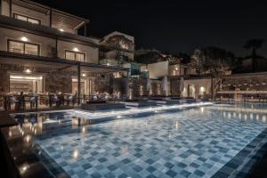 a swimming pool at night with a resort at Enigma Mykonos Hideaway Suites in Ornos