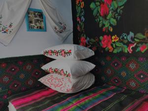 a pile of pillows sitting on top of a bed at La Mădălina in Selemet