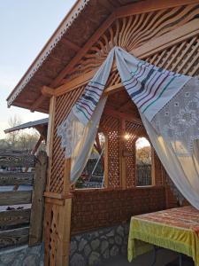 a wooden house with a canopy with a bed in it at La Mădălina in Selemet