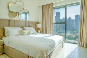 a bedroom with a large bed and a large window at FIRST CLASS 2BR with full BURJ KHALIFA view in Dubai