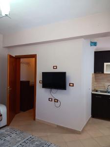 a living room with a flat screen tv on a wall at Alvi apartment in Shkodër