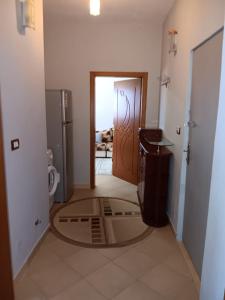 a hallway with a door to a bathroom with a refrigerator at Alvi apartment in Shkodër