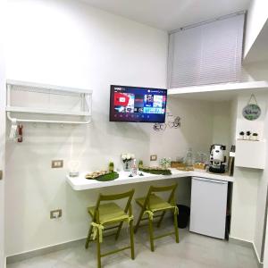 eine Küche mit 2 Stühlen und einer Theke mit einem TV an der Wand in der Unterkunft All-in in Neapel
