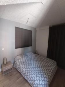 een slaapkamer met een bed en een flatscreen-tv bij Le petit Beure in Beure