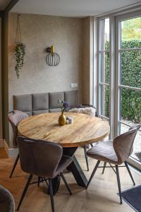 een eetkamer met een houten tafel en stoelen bij DreamZzz Boutique B&B Kaatsheuvel in Kaatsheuvel