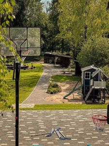 een basketbalring in een park met een speeltuin bij Villa Lakstīgalas in Skrīveri