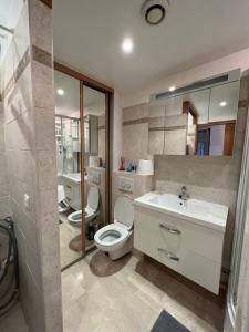 a bathroom with a toilet and a sink and a mirror at Courbevoie Riverview in Courbevoie