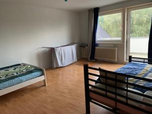 1 Schlafzimmer mit 2 Betten und einem großen Fenster in der Unterkunft Solinger Wohnung in Solingen