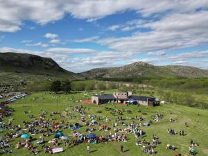 a large crowd of people in a field with mountains in the background at LO DE LOPEZ in Azul