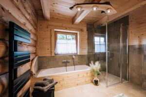un bagno con vasca in una baita di tronchi di Webertonihütte a Bad Sankt Leonhard im Lavanttal Altre 37 foto