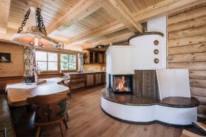 una cucina e un soggiorno con camino in una baita di tronchi. di Webertonihütte a Bad Sankt Leonhard im Lavanttal