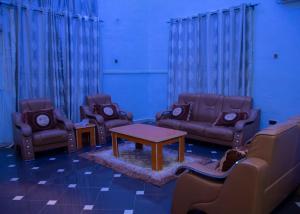 een woonkamer met banken en een tafel en stoelen bij Home to Home luxury apartments and suites in Benin City