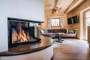 una sala de estar con chimenea en una casa de madera en Webertonihütte en Bad Sankt Leonhard im Lavanttal