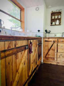 a kitchen with wooden cabinets and a wooden barn door at Eulennest - Tiny House im Habichtswald in Schauenburg