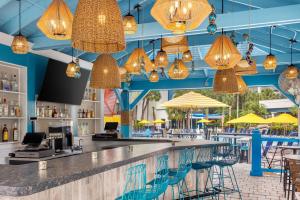 a bar in a restaurant with blue ceilings and yellow umbrellas at Delta Hotels by Marriott Orlando Celebration in Orlando