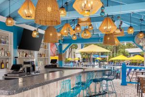 a bar in a restaurant with blue ceilings and yellow umbrellas at Delta Hotels by Marriott Orlando Celebration in Orlando